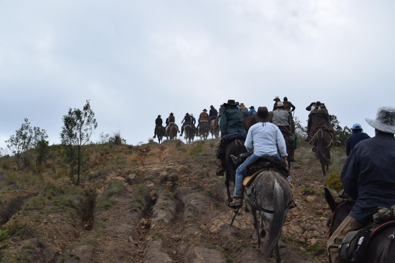 Grupo de jinetes subiendo una loma seca y empinada en la cabalgata Suesca – Cucunubá, Suesca